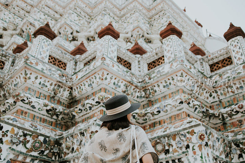 年轻的亚洲妇女在Wat Arun Ratchawararam旅游，其中一个著名的地方在曼谷，泰国库存照片